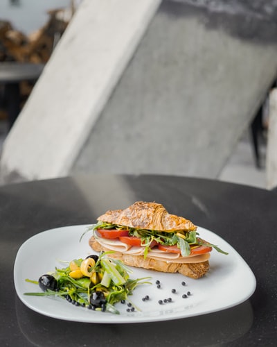 sliced bread with green vegetable on white ceramic plate